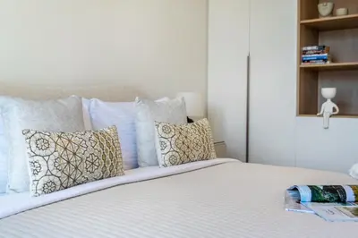 a bed with white sheets and pillows in a bedroom at The Smart Concierge - La Rive Port De Lamer in Dubai