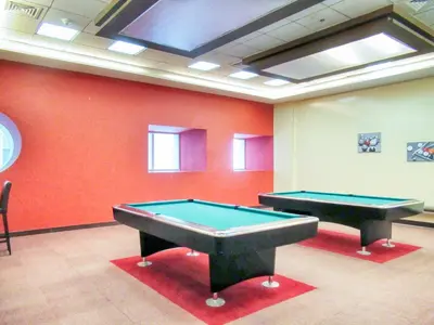 two pool tables in a room with orange walls at The Smart Concierge - Elite residence in Dubai