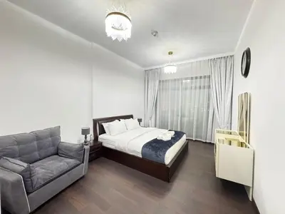 a bedroom with a bed and a couch at Stay in the heart of Sport City in LUX 1BDR with sky view 11 in Dubai