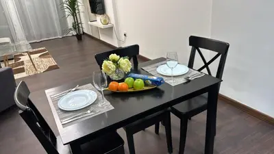 a black table with a bowl of fruit and wine glasses at Stay in the heart of Sport City in LUX 1BDR with sky view 11 in Dubai