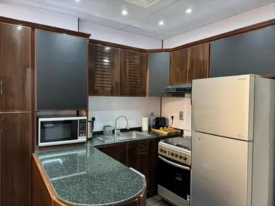 a kitchen with a white refrigerator and a counter top at Stay in the heart of Sport City in LUX 1BDR with sky view 11 in Dubai