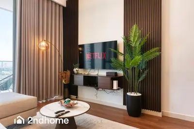 a living room with a tv and a plant at 2ndHome - Downtown Views 1 - Downtown Dubai in Dubai