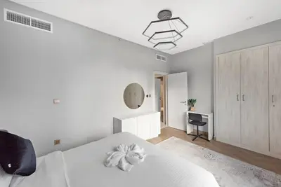 a white bedroom with a white bed and a desk at FIRST CLASS 2BR Incredible Burj Khalifa View in Dubai