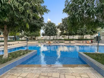 a swimming pool with blue water in a park at FIRST CLASS 2BR Incredible Burj Khalifa View in Dubai