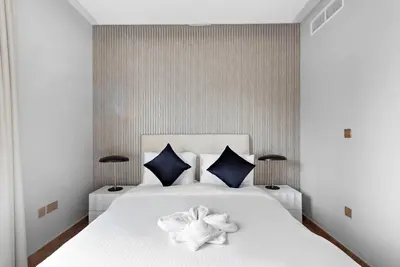 a bedroom with a white bed with a flower on it at FIRST CLASS 2BR Incredible Burj Khalifa View in Dubai