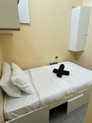 a bed with a black hat on top of it at Hostel with Private Room near Downtown Business Bay in Dubai