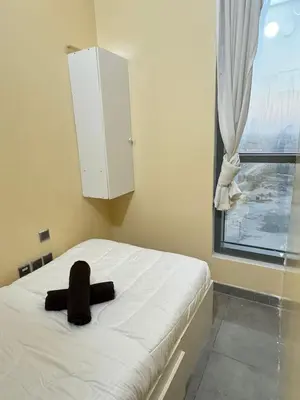 a bedroom with a white bed and a window at Hostel with Private Room near Downtown Business Bay in Dubai