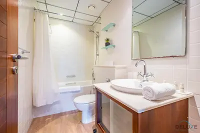 a bathroom with a sink and a toilet and a mirror at Beautiful 2BR apartment in Al Sahab 2, Dubai Marina by Deluxe Holiday Homes in Dubai