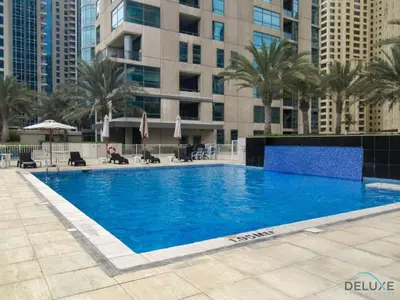 a large swimming pool with palm trees and buildings at Beautiful 2BR apartment in Al Sahab 2, Dubai Marina by Deluxe Holiday Homes in Dubai