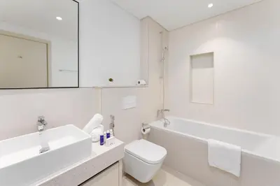 a white bathroom with a sink and a toilet at Maison Privee - Exclusive Apt w/ Unmatched Dubai Marina Vistas in Dubai