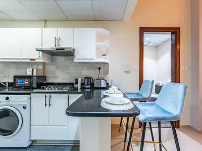 a kitchen with a table with chairs and a stove at Elite Vista Studio Elite 10 Sports Residences in Dubai