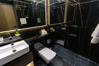 a bathroom with a toilet and a sink and a mirror at CitiHome - 1BR Freshly Styled and Comfortable in JVC in Dubai
