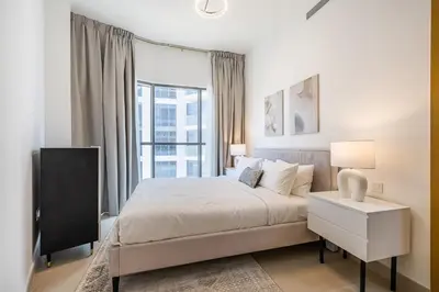 a white bedroom with a bed and a window at Apartment with Burj Khalifa View I Bellevue Tower in Dubai