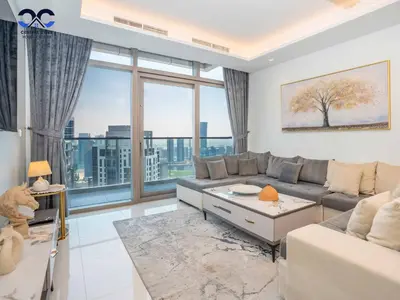 a living room with a couch and a large window at Paramount Downtown Burj Khalifa View with 64th floor Infinity pool in Dubai