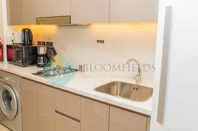 a kitchen counter with a sink and a microwave at Bloomfields Cozy Stu Azizi Riviera Meydan in Dubai
