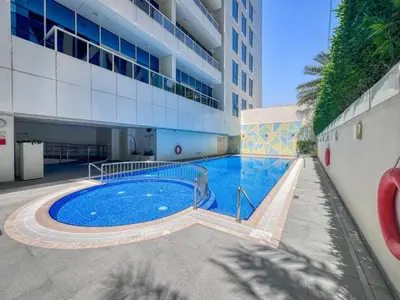 a large swimming pool in front of a building at GuestReady - Luxury haven at Marina Arcade in Dubai