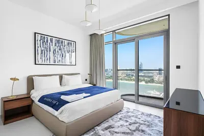 a bedroom with a bed and a large window at Family Friendly 2BDR With Sea & City View in Dubai