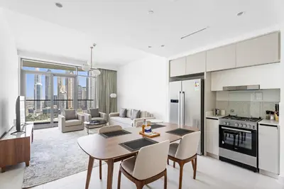 a kitchen and living room with a table and chairs at Family Friendly 2BDR With Sea & City View in Dubai