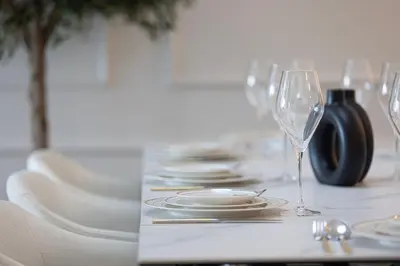 a table with plates and a wine glass on it at Luxury 4BR Burj Khalifa & Fountain Views in Dubai
