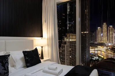a bedroom with a large window with a city skyline at Luxury 4BR Burj Khalifa & Fountain Views in Dubai
