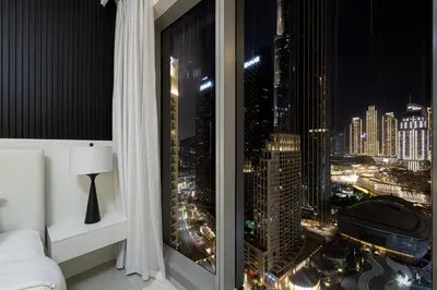 a bedroom with a view of a city at night at Luxury 4BR Burj Khalifa & Fountain Views in Dubai
