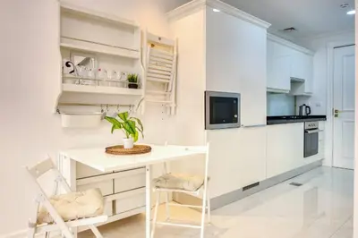 a kitchen with white cabinets and a white desk at Studio Apartment in Vincitore Palacio Arjan in Dubai
