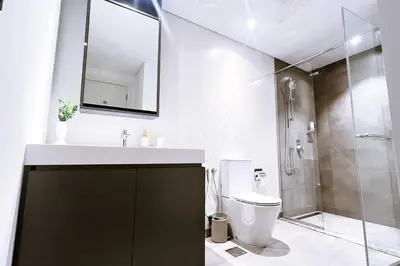 a bathroom with a sink and a toilet and a shower at Brand New 1 Bedroom Apartment JVC in Dubai