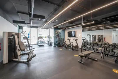 a gym with several treadmills and cardio machines at Luxury Living in Marina Liv Residence 2BR in Dubai