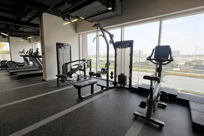 a gym with a row of treadmills and machines at Brand New Apartment in Socio Tower Dubai Hills in Dubai