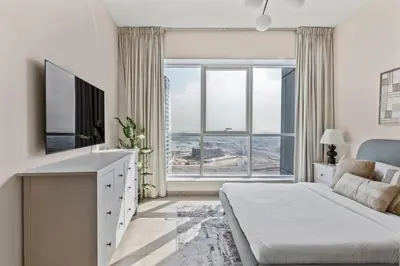 a bedroom with a bed and a large window at GuestReady - Luxury haven in JLT in Dubai