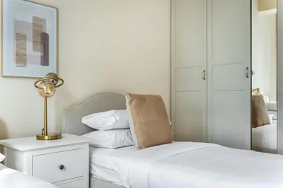 a bedroom with two beds and a lamp on a night stand at GuestReady - Luxury haven in JLT in Dubai