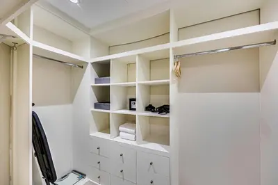 a walk in closet with white shelves at Spacious 1BD apartment in the Residence North in Dubai