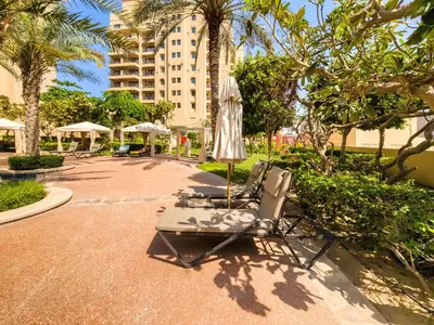 a couple of lounge chairs and an umbrella at Spacious 1BD apartment in the Residence North in Dubai