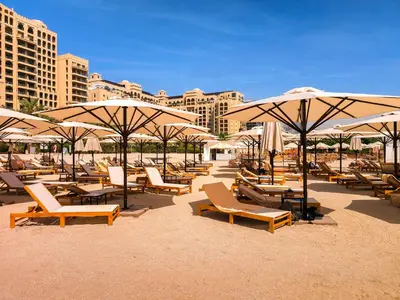 a bunch of chairs and umbrellas on a beach at Spacious 1BD apartment in the Residence North in Dubai