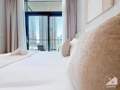 a bedroom with a large white bed with a large window at Luxury Burj Crown 4bedroom Balcony & Downtown View in Dubai