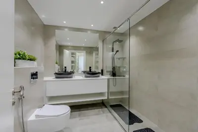 a bathroom with two sinks and a toilet at Al Hatimi, Shoreline Apartments, Palm Jumeirah, Dubai in Dubai