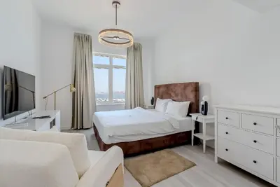 a bedroom with a bed and a tv and a couch at Al Hatimi, Shoreline Apartments, Palm Jumeirah, Dubai in Dubai
