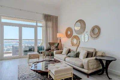 a living room with a couch and a large window at Al Hatimi, Shoreline Apartments, Palm Jumeirah, Dubai in Dubai