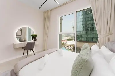 a white bedroom with a bed and a window at Beachfront Luxury Living at La Vie Residence JBR in Dubai
