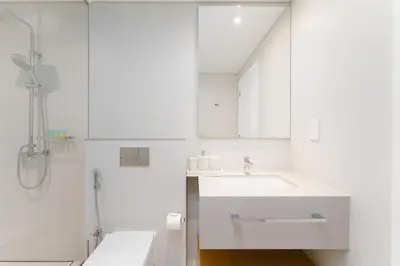 a white bathroom with a sink and a shower at Beachfront Luxury Living at La Vie Residence JBR in Dubai