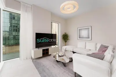 a white living room with a white couch and a tv at Beachfront Luxury Living at La Vie Residence JBR in Dubai