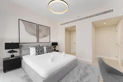a white bedroom with a bed and a mirror at Beachfront Luxury Living at La Vie Residence JBR in Dubai