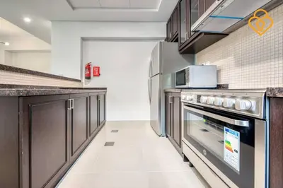 a kitchen with stainless steel appliances and brown cabinets at Keysplease Beautiful 3 B/R Villa With Garden, Serena in Dubai