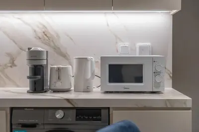 a microwave and other appliances on a counter at Clever Guest 021 Condor Marina Star in Dubai