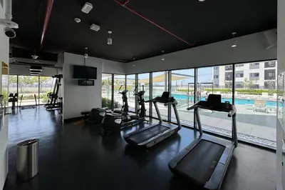 a gym with treadmills and ellipticals in a building at Comfortable 2BD apartment next to metro & mall in Dubai