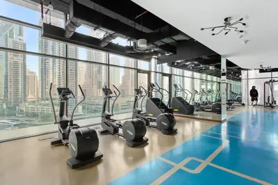 a gym with treadmills and ellipticals in a building at Marina Gate - Stunning 56 Floor Full Sea Views in Dubai