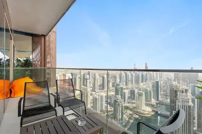a balcony with two chairs and a view of a city at Marina Gate - Stunning 56 Floor Full Sea Views in Dubai