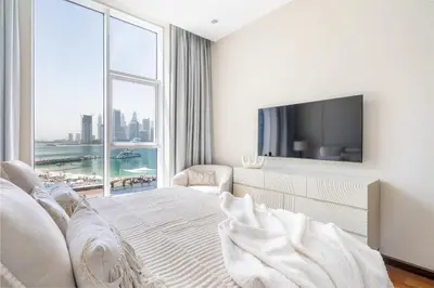 a bedroom with a bed and a large window at Oceana Luxury 4 BR Apartment with Resort Access and Sea Views by Exclusive Holiday Homes in Dubai