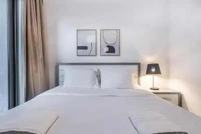 a bedroom with a large white bed with white pillows at Sobha Creek Vistas Cozy 1BDR with balcony in Dubai
