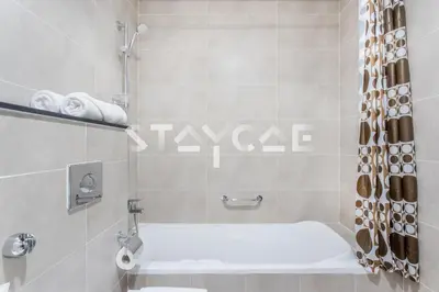 a bathroom with a white tub and a shower at Staycae Holiday Homes - Carson Towers in Dubai